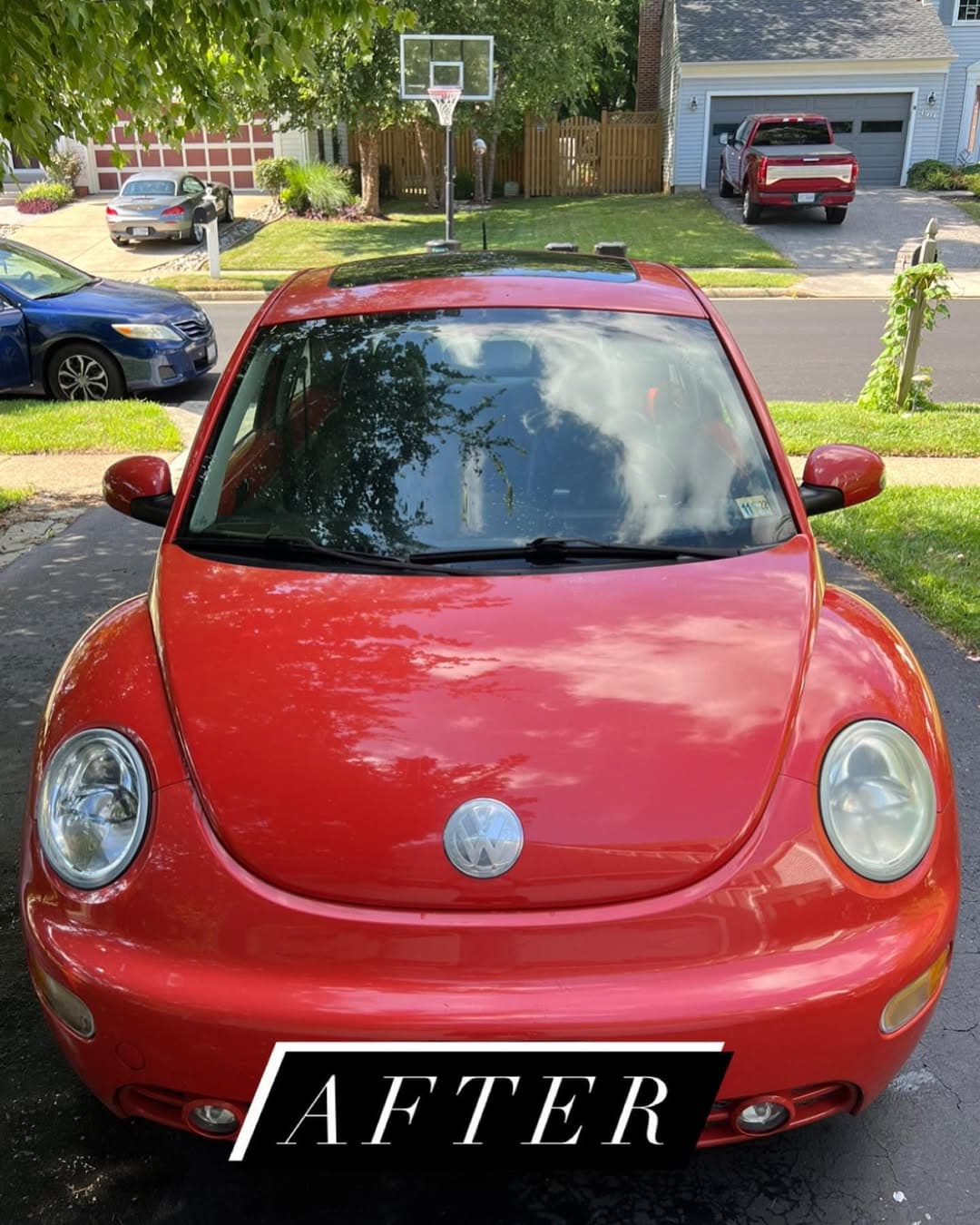 A polished red Volkswagen parked outdoors.